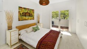 a bedroom with a bed and a painting on the wall at Mackaren's Lodge - Chic in Macmasters Beach