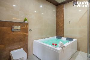 a bathroom with a tub with two glasses of wine at StayVista at The Binclave with Jacuzzi, Pvt Indoor Pool, Bar & Projector in Jaipur