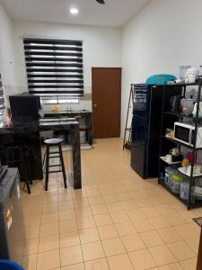 a room with a kitchen with a table and a stool at Hasna Homestay Cherating Muslimonly in Kuantan