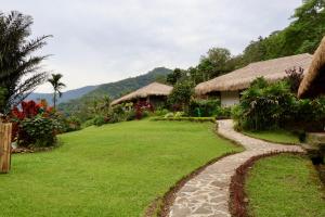 a garden with a path leading to a house at Kelimutu Crater Lakes Ecolodge in Kelimutu