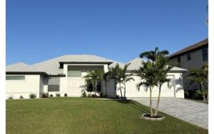 a large white house with palm trees in the yard at Sandi Villa in Cape Coral