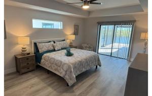 a bedroom with a bed and two lamps and a sliding glass door at Sandi Villa in Cape Coral +39 photos