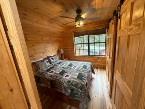 a bedroom with a bed in a wooden cabin at Small Cabin Over Garage with lake access and small dock in Sevierville