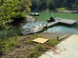 a dock on a river with a boat in the water at Small Cabin Over Garage with lake access and small dock in Sevierville