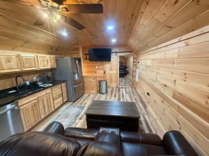 a living room with a leather couch and a kitchen at Small Cabin Over Garage with lake access and small dock in Sevierville