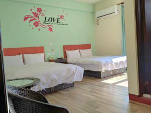 a hotel room with two beds and a table and chairs at 池上投優榻 Smart living B&B in Chishang