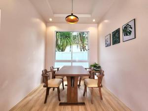 a dining room with a table and chairs and a window at Benjavipa Pool Villa Khao yai in Ban Nong Song Hong