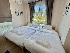 two beds in a small room with a window at Benjavipa Pool Villa Khao yai in Ban Nong Song Hong +17 photos
