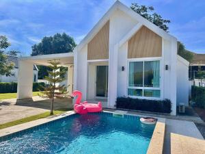 a pool with a pink swan in front of a house at Benjavipa Pool Villa Khao yai in Ban Nong Song Hong