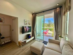 a living room with a couch and a large window at Benjavipa Pool Villa Khao yai in Ban Nong Song Hong