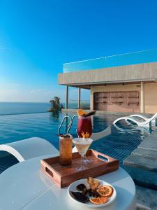 a tray with a drink on a table next to a pool at Mandala Twilight Haven 5 Star in Phan Thiet