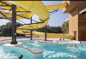 a group of people in a pool with a water slide at Villa the Tulip JACK in Julianadorp