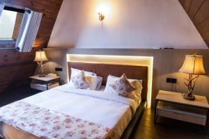 a bedroom with a large bed with white sheets and pillows at Kubana in Nuwara Eliya