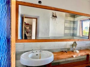 a bathroom with a white sink and a mirror at Casa del lago in Embalse +12 photos