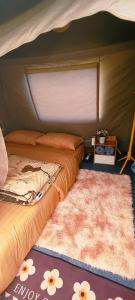 two beds in a tent with a rug and a table at Doi Inthanon Waterfall Garden in Ban Sop Mae Klang