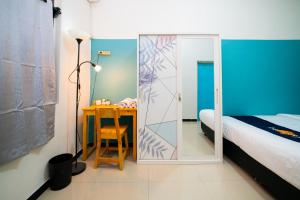 a bedroom with a bed and a desk with a mirror at Behomy Yume Grogol in Jakarta