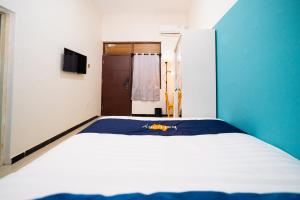 a bed in a room with a blue and white at Behomy Yume Grogol in Jakarta