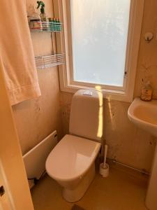 ein Badezimmer mit Toilette, Waschbecken und Fenster in der Unterkunft Kalvsvik in Värmdö + 8 Fotos