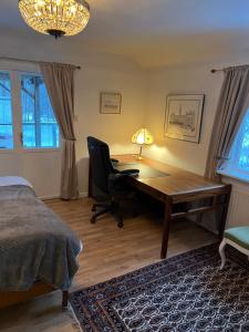 ein Schlafzimmer mit Schreibtisch, Stuhl und Bett in der Unterkunft Kalvsvik in Värmdö