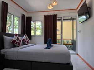a bedroom with a bed with a television and windows at NO name bangalow in Ko Lanta Yai