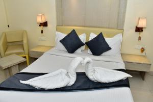 a hotel room with two swans laying on a bed at The Rass in Kānpur