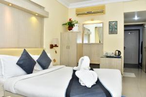 a bedroom with a white bed with a stuffed animal on it at The Rass in Kānpur