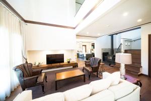a living room with a white couch and a tv at Wataya - 市原 和多屋- in Ichihara
