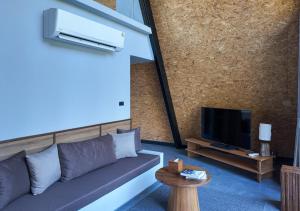 a living room with a couch and a tv at Khunkhao Paradise Khao Yai in Ban Rai Khlong Sai