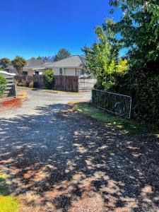a driveway in front of a house with a fence at Cosy Corner Te Anau in Te Anau