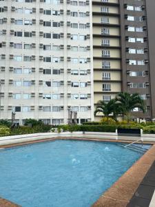 an empty swimming pool in front of a tall building at Avida Aspira Studio 18th in Cagayan de Oro
