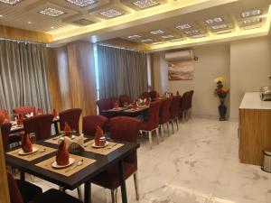 a restaurant with tables and chairs in a room at Hotel Teesta Stay, Kolkata in kolkata