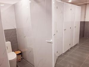 a bathroom with a toilet and a white wall at Homestay & Camping Phan Thiet Beach in Ấp Bình Hưng +22 photos