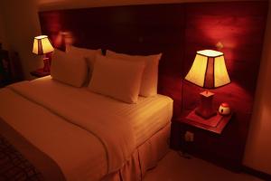 1 dormitorio con 1 cama blanca y 2 lámparas en Unique Towers Luxury Boutique Suites en Colombo