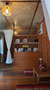 a living room with a table and a book shelf at Slow Home in Ban Yang Mae Luang