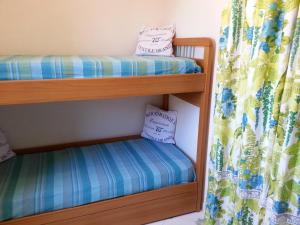 two bunk beds in a room with a curtain at Villetta Cala Rotonda in Favignana