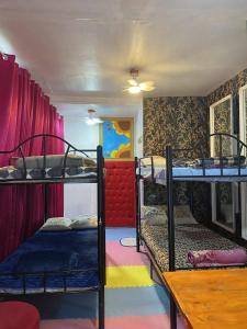 a room with three bunk beds and a table at Budget Traveler Only Home in Legazpi