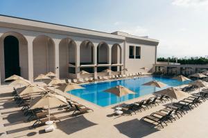 a large swimming pool with chairs and umbrellas at Villa Mosavali in Akhalubani