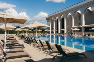 a swimming pool with lounge chairs and umbrellas at Villa Mosavali in Akhalubani