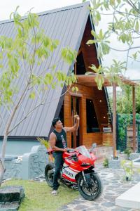 a man standing next to a motorcycle in front of a house at Senu Lee Cabana in Galle +11 photos