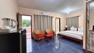 a hotel room with a bed and a table and chairs at Sunset INN by Pro-Ema in Dili +49 photos