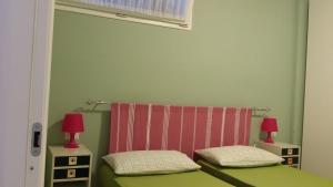 a bedroom with two beds and two red lamps at Lacona Casa Franca in Lacona