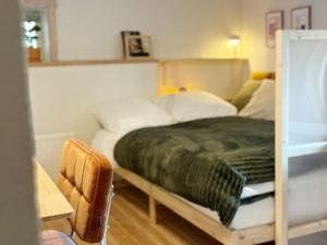 a bedroom with a bed with a green blanket on it at Rabygatan cottage in Old Limhamn in Malmö