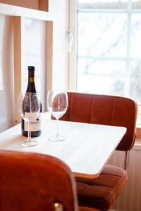 a bottle of wine and two wine glasses on a table at Rabygatan cottage in Old Limhamn in Malmö