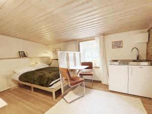 a bedroom with a bed and a table and a kitchen at Rabygatan cottage in Old Limhamn in Malmö