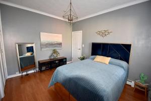 a bedroom with a blue bed and a television at Cerca de Nueva York, Confortable in West New York