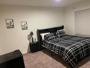 a bedroom with a bed with a black and white plaid blanket at Inner Haven Family Homes in Indianapolis