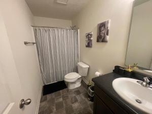 a bathroom with a toilet and a sink and a shower at Inner Haven Family Homes in Indianapolis +18 photos