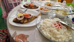 a table with plates of food and rice on it at Vivid Lanka in Bentota