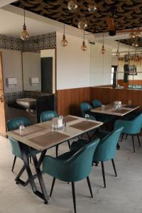 a dining room with tables and blue chairs at Sovas Nature Hideout in Kolvan