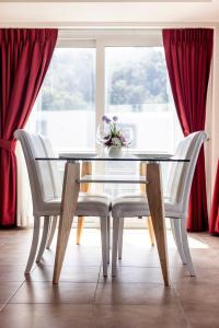 a glass dining table with two white chairs and a window at ELEGANT Kata sea View Apartmens in Kata Beach